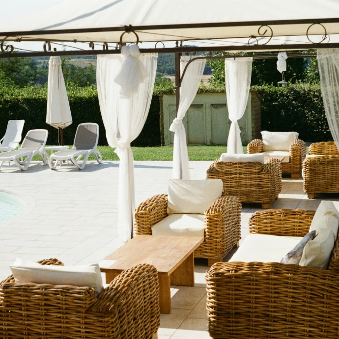 Elegant outdoor lounge under a white gazebo by a pool
